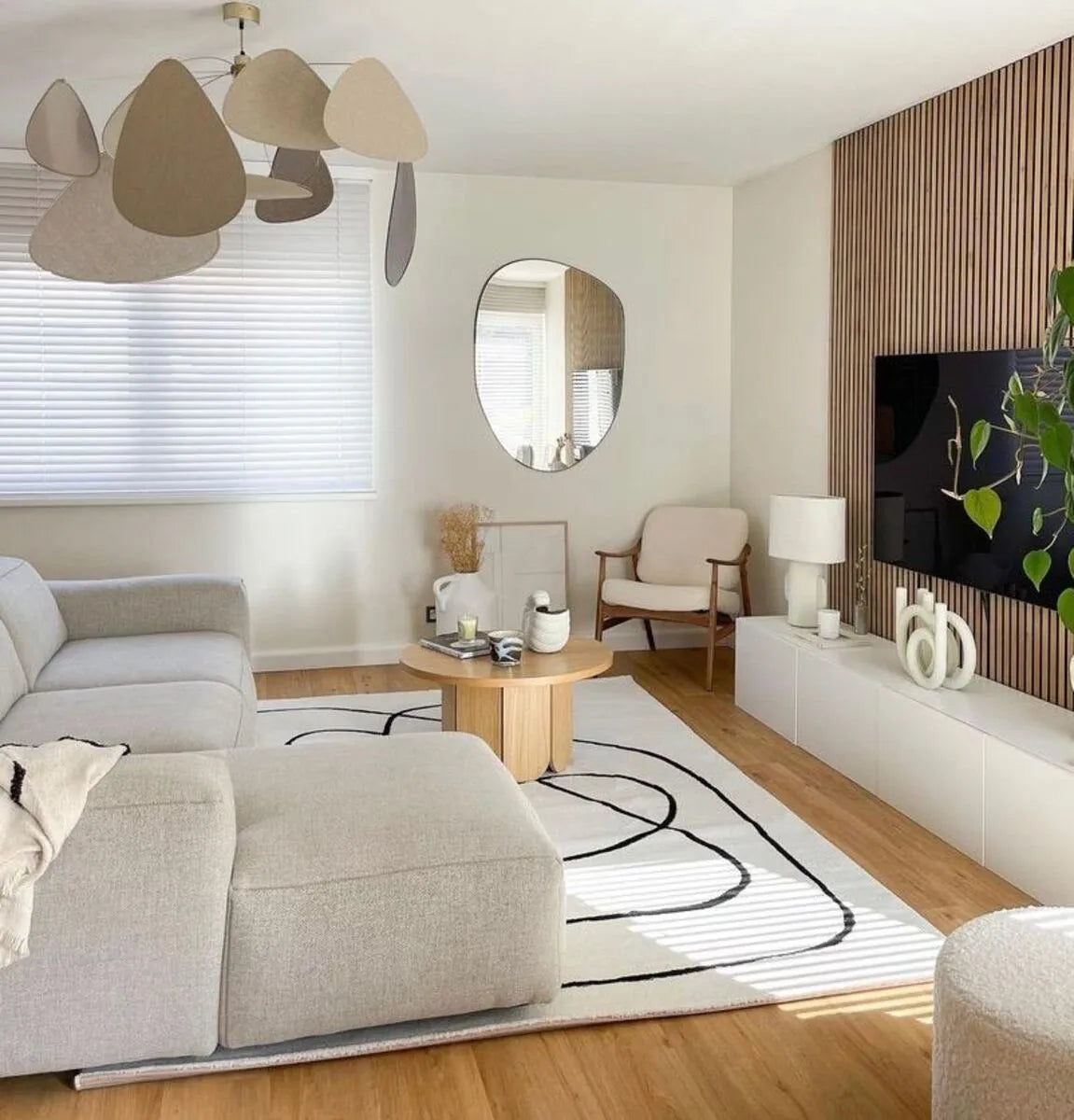 Salon élégant avec canapé beige, table basse en bois et décoration minimaliste.